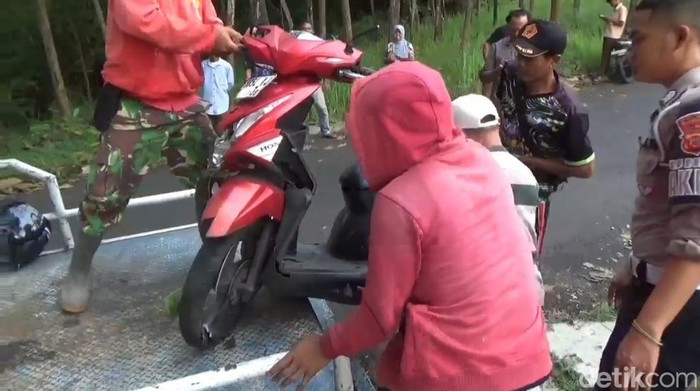 Sejumlah orang bersama petugas mengevakuasi motor yang alami kecelakaan di Sumedang.