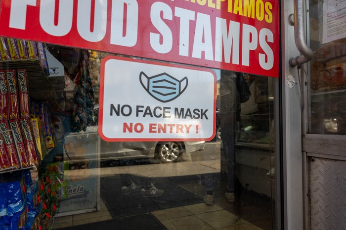 NEW YORK, NEW YORK - MARCH 11: An old sign in a window of a closed business asks customers to wear a mask to prevent the spread of  COVID-19 as the nation marks the fifth anniversary of the Covid-19 pandemic on March 13, 2025 in New York City. While the pandemic is mainly contained and most Americans have returned to the office, thousands of people still contract the virus monthly. As of March 6, at least 1,222,603 Americans have died of COVID-19, according to data from the Centers for Disease Control and Prevention. (Photo by Spencer Platt/Getty Images)