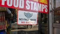 Sisa-sisa papan pengingat untuk memakai masker masih terpasang di sebuah toko di New York City. Foto diambil pada 13 Maret 2023, saat AS memperingati 5 tahun pandemi COVID-19. Foto: Getty Images/Spencer Platt