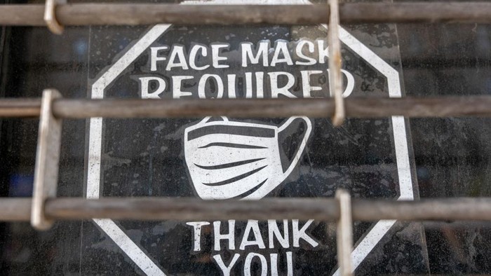 NEW YORK, NEW YORK - MARCH 11: An old sign in a window of a closed business asks customers to wear a mask to prevent the spread of  COVID-19 as the nation marks the fifth anniversary of the Covid-19 pandemic on March 13, 2025 in New York City. While the pandemic is mainly contained and most Americans have returned to the office, thousands of people still contract the virus monthly. As of March 6, at least 1,222,603 Americans have died of COVID-19, according to data from the Centers for Disease Control and Prevention. (Photo by Spencer Platt/Getty Images)