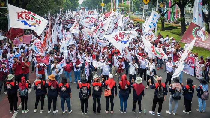 Aksi buruh tolak impor tekstil ilegal Sejumlah buruh mengibarkan bendera saat aksi menolak impor tekstil ilegal di Jakarta, Minggu (1/6/2025). Mereka menuntut pemerintah untuk memberantas praktik impor tekstil ilegal, memperketat aturan impor untuk melindungi keberlangsungan industri padat karya dalam negeri dan melakukan tindakan antisipatif untuk mencegah terjadinya PHK semakin meluas. ANTARA FOTO/Putra M. Akbar/nym.