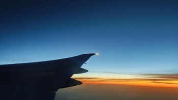 Suasana menjelang Matahari terbit dipotret dari dalam pesawat dalam kondisi low light, warna sesuai dengan suasana aslinya. Untuk diketahui, pada foto ini terdapat pantulan kaca jendela pesawat, sehingga diterapkan pengeditan minor menggunakan AI remove reflections untuk menghilangkan pantulan kaca. Foto: Rachmatunnisa/detikINET