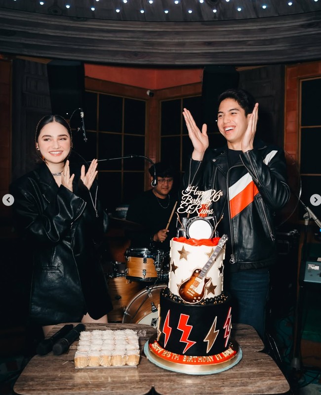 Bertema musik rock, Syifa Hadju dan El tampil kompak dan serasi dalam balutan jaket kulit berwarna hitam. Senada dengan temanya, kue ulang tahun El dibuat dengan dominasi warna hitam, putih, merah, dan gold. Terdapat gambar gitar dan drum yang menghiasi kue. Pada bagian atas dan bawah kue juga terdapat tulisan Happy 26th Birthday El Rumi. Foto: Instagram/@elelrumi