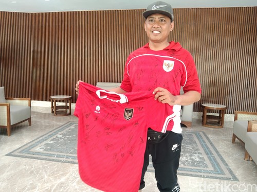 Heri Istiawan memamerkan jersey dengan penuh tanda tangan pemain Timnas Indonesia, Minggu (1/6/2025). (Krisna Pradipta)