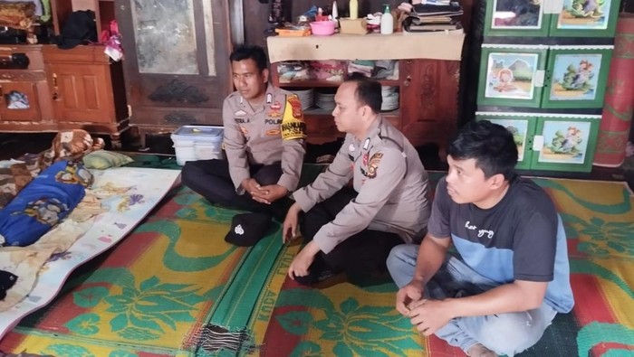 Polisi saat berada di rumah duka korban yang hanyut di Sungai Enim Muara Enim.