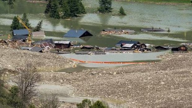 This photograph shows debris and the rest of the village of Blatten now submerged by the obstructed river Lonza, after the huge Birch Glacier collapsed and a massive landslide that threw tons of rock, ice and scree down the mountainside and into the valley below, in Wiler, in the Swiss Alps, on May 31, 2025. Swiss authorities said on May 30, 2025 that they were no longer considering evacuating most residents in the vicinity of a collapsed glacier that destroyed a village, but that they remained vigilant. The Birch glacier in Switzerland's southern Valais region collapsed on May 28, 2025 sending a mass of rock, ice and scree hurtling into the village of Blatten in the valley below. (Photo by Fabrice COFFRINI / AFP)