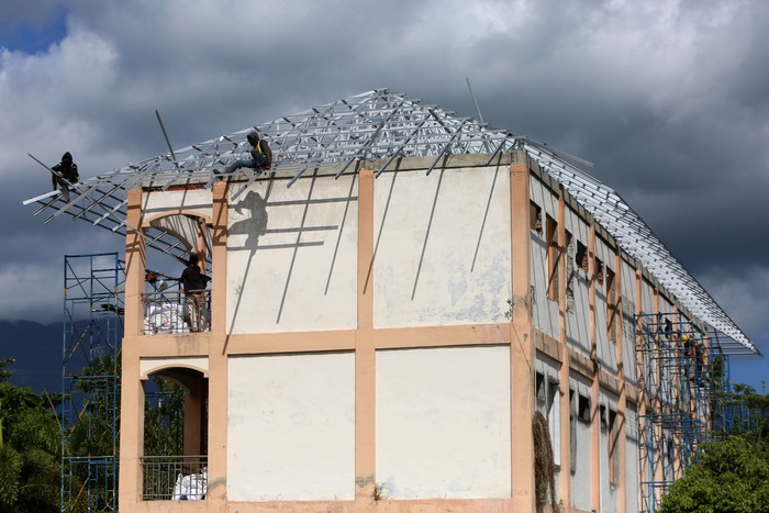 Renovasi gedung bertingkat untuk sekolah rakyat di Aceh Pekerja menyelesaikan pemasangan atap bangunan saat renovasi gedung bertingkat untuk sekolah rakyat di kompleks Sekolah Unggul Ali Hasjmy, Kabupaten Aceh Besar, Aceh, Minggu (1/6/2025). Kementerian Sosial (Kemensos) memproyeksikan sebanyak 100.000 anak dari keluarga miskin dan miskin ekstrem akan menjalani kegiatan belajar menyusul dibukanya sebanyak 100 sekolah rakyat pada tahun ajaran baru mulai Juli 2025 dengan kuota 1.000 siswa per sekolah. ANTARA FOTO/Ampelsa/nym.