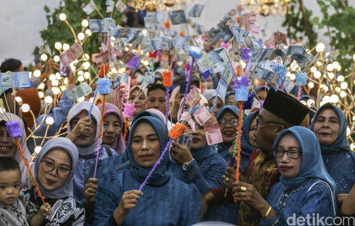 Tradisi unik pernikahan suku Makian di Ternate Tamu undangan memberikan uang pecahan Rp100 ribu dan Rp50 ribu kepada pengantin saat prosesi Saro-saro di Ternate, Maluku Utara, Minggu (1/6/2025). Suku Makian memiliki tradisi unik untuk menyambut pasangan pengantin yang baru menikah yaitu Saro-saro sebagai lambang harapan untuk kehidupan perkawinan bahagia dan harmonis. ANTARA FOTO/Andri Saputra/rwa.
