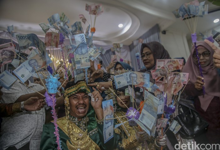 Tamu undangan memberikan uang pecahan Rp100 ribu dan Rp50 ribu kepada pengantin saat prosesi Saro-saro di Ternate, Maluku Utara, Minggu (1/6/2025). Suku Makian memiliki tradisi unik untuk menyambut pasangan pengantin yang baru menikah yaitu Saro-saro sebagai lambang harapan untuk kehidupan perkawinan bahagia dan harmonis. ANTARA FOTO/Andri Saputra/rwa.