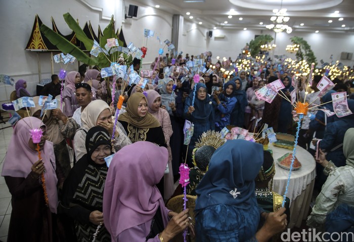 Tradisi unik pernikahan suku Makian di Ternate Tamu undangan memberikan uang pecahan Rp100 ribu dan Rp50 ribu kepada pengantin saat prosesi Saro-saro di Ternate, Maluku Utara, Minggu (1/6/2025). Suku Makian memiliki tradisi unik untuk menyambut pasangan pengantin yang baru menikah yaitu Saro-saro sebagai lambang harapan untuk kehidupan perkawinan bahagia dan harmonis. ANTARA FOTO/Andri Saputra/rwa.