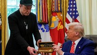 Dalam acara itu, Trump juga memberi Musk sebuah kunci emas besar di dalam kotak kayu bertanda tangannya, hadiah yang katanya hanya ia simpan untuk orang-orang yang sangat istimewa. Foto: REUTERS/Nathan Howard