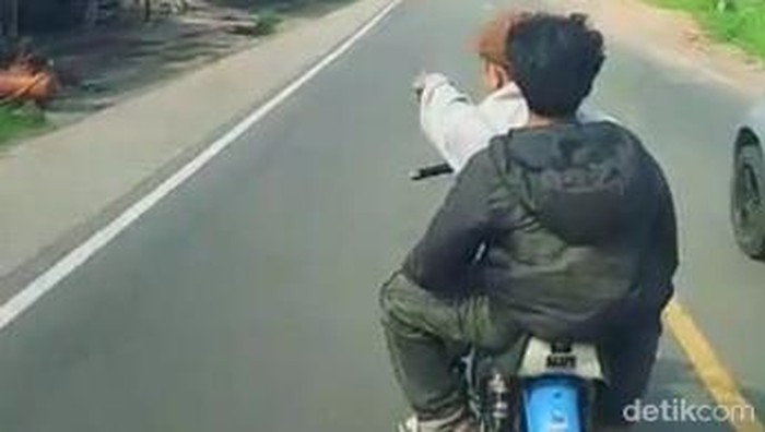 Dua pemuda mencoba menghentikan truk di Jalan Raya Ciaro, Nagreg, Kabupaten Bandung