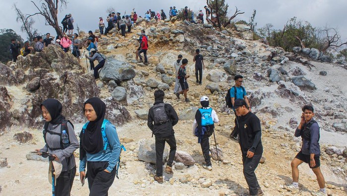 Pengunjung berfoto dengan latar belakang Kawah Ratu di Kawasan Taman Nasional Gunung Halimun Salak, Kabupaten Bogor, Jawa Barat, Sabtu (31/5/2025). Objek wisata alam yang menawarkan hamparan keindahan kawah alami itu menjadi salah satu destinasi favorit saat akhir pekan dan liburan. ANTARA FOTO/Fathul Habib Sholeh/Spt.