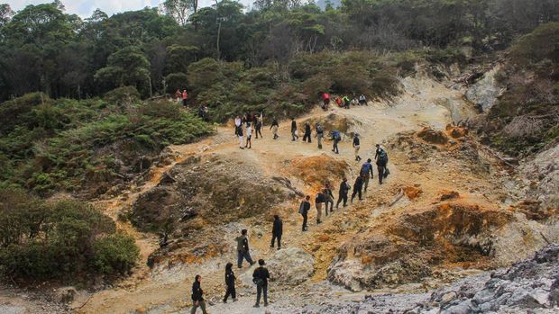 Pengunjung berfoto dengan latar belakang Kawah Ratu di Kawasan Taman Nasional Gunung Halimun Salak, Kabupaten Bogor, Jawa Barat, Sabtu (31/5/2025). Objek wisata alam yang menawarkan hamparan keindahan kawah alami itu menjadi salah satu destinasi favorit saat akhir pekan dan liburan. ANTARA FOTO/Fathul Habib Sholeh/Spt.