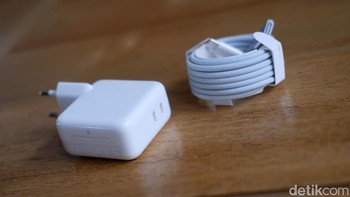 MacBook Air M4 masih menyertakan Adaptor Daya 35W dengan dua port USB-C yang fungsional. Namun, sorotan utamanya adalah kabel MagSafe 3 baru yang kini menggunakan bahan braided nylon (anyaman nilon). Bahan ini membuatnya jauh lebih awet dan tidak mudah kusut. Paling menarik, warna kabelnya dibuat senada dengan unit Sky Blue, memberikan tampilan yang serasi dan premium. Foto: Adi Fida Rahman/detikINET