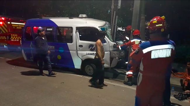 Mobil angkot menabrak tiang listrik di kawasan Sunter, Jakut. Petugas damkar mengevakuasi mobil angkot yang ringsek tersangkut di tiang listrik. (dok Damkar Jakut)
