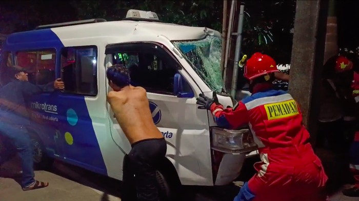 Mobil angkot menabrak tiang listrik di kawasan Sunter, Jakut. Petugas damkar mengevakuasi mobil angkot yang ringsek tersangkut di tiang listrik. (dok Damkar Jakut)