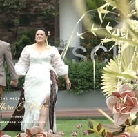 Keduanya juga sempat berganti pakaian namun tetap dengan menerapkan unsur tradisional. Rafli mengenakan beskap coklat muda dipadukan dengan kain jarik Jawa. Sementara Putri mengenakan gaun putih berbelahan hingga ke paha. Gaun tersebut memiliki tambahan aksen kain batik coklat untuk mempertahankan unsur tradisionalnya. Foto: YouTube/Putri Habibie
