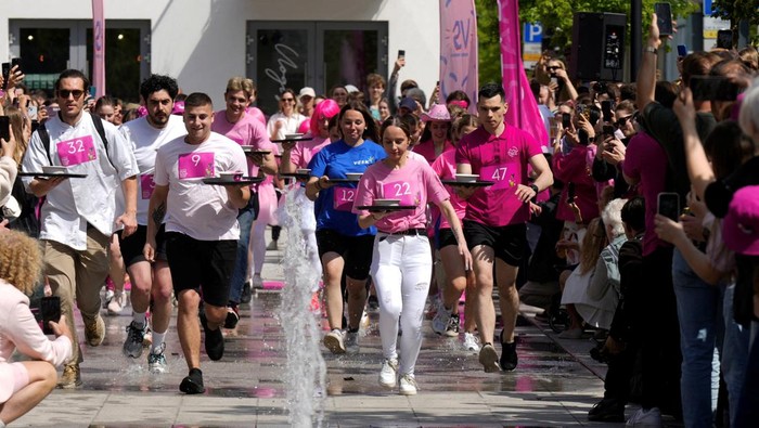 Semarak Warga Lithuania Rayakan Sup Bit Dingin Favorit Musim Panas A woman enjoys sliding down the 50-meter-long pink slide during the Pink Soup Fest in Vilnius, Lithuania May 31, 2025. REUTERS/Ints Kalnins TPX IMAGES OF THE DAY