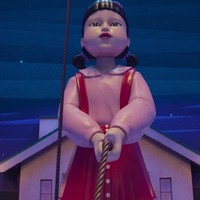 Boneka robot legendaris Squid Game, Young Hee muncul lagi dengan kostum yang lebih mencekam, tidak lagi bernuansa oranye-kuning. Young Hee mengawasi pergerakan peserta dengan mata laser-nya dan memegang tali raksasa. Squid Game 3 akan segera tayang di Netflix pada 27 Juni 2025. Foto: dok. Netflix