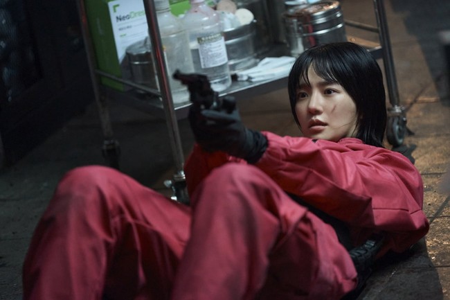 Squid Game akhirnya memberikan POV dari seorang pink guard sejak penayangan season kedua. No Eul (pemain Park Gyu Young) tampak mengarahkan pistol kepada seseorang untuk melindungi dirinya. Foto: dok. Netflix