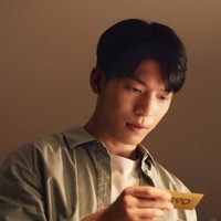 Sejak season pertama Squid Game, Hwang Jun Ho (pemain Wi Ha Joon) mencoba berbagai cara untuk menemukan kakak laki-lakinya Front Man dan lokasi permainan bertahan hidup. Dia kini menemukan petunjuk berupa kartu undangan. Foto: dok. Netflix