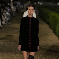Sebuah gaun renda hitam dipadukan dengan mantel wol tebal berwarna krem bergaya militer dengan ekor panjang, sementara tampilan lainnya dilengkapi dengan jubah trench berkerah tinggi, jaket motor mini seukuran bolero, atau tailcoat krem yang mengingatkan pada gaya ikonik Marlene Dietrich. (Foto: Giovanni Giannoni/WWD via Getty Images)