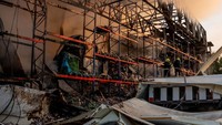 Petugas darurat membantu mengevakuasi penduduk dari apartemen yang terdampak serangan di tengah meningkatnya eskalasi konflik. REUTERS/STATE EMERGENCY SERVICE