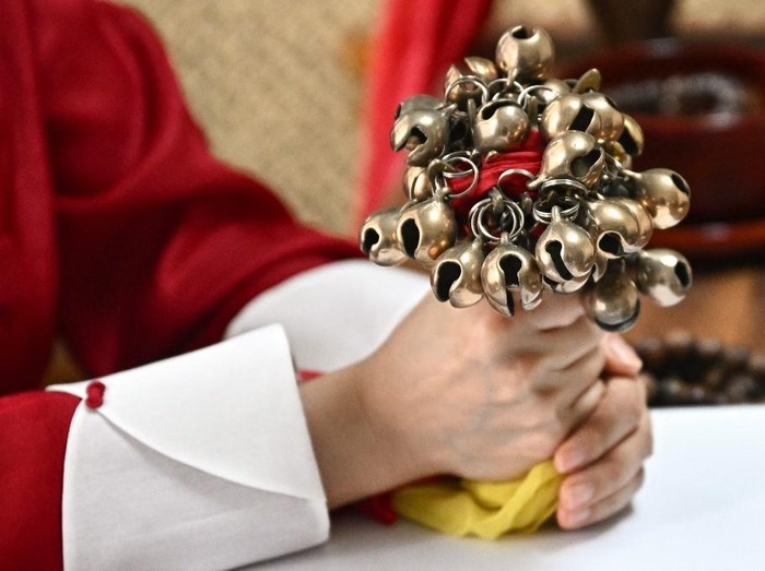This picture taken on May 30, 2025 shows Shaman Yang Su-bong holding ritual bells after an interview with AFP at her house in Incheon. The outcome of this weeks presidential elections in South Korea may still be unknown, but shaman Yang Su-bong tells AFP the winner came to her in visions years ago. (Photo by Pedro Pardo / AFP) / To go with SKOREA-VOTE-RELIGION-SHAMANS, FOCUS by SHIM Kyu-Seok