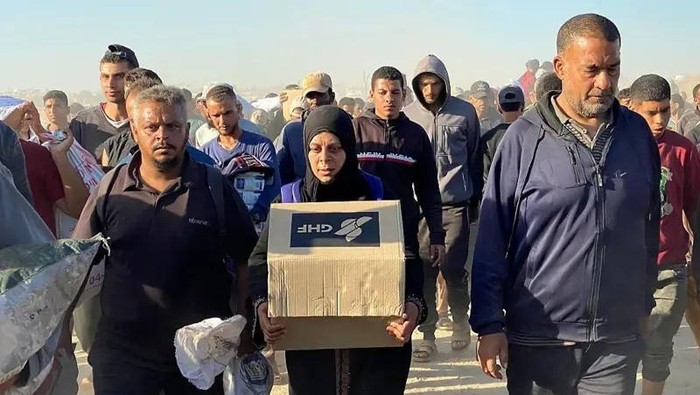 Seorang wanita membawa kotak berisi perlengkapan bantuan dari Yayasan Kemanusiaan Gaza (GHF), 29 Mei 2025. (AFP VIA GETTY IMAGES)
