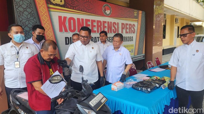 Antoni memperagakan saat dirinya hendak menurunkan sabu dari motor lalu ditangkap polisi.