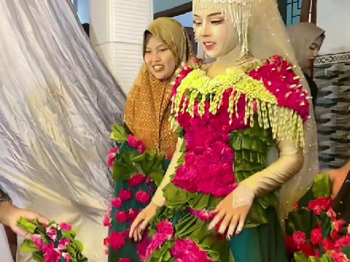 Beredar video viral pengantin wanita memakai busana pengantin dari daun pisang dan kelopak bunga mawar di hari pernikahannya.