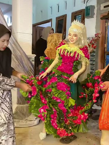 Beredar video viral pengantin wanita memakai busana pengantin dari daun pisang dan kelopak bunga mawar di hari pernikahannya.