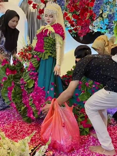 Beredar video viral pengantin wanita memakai busana pengantin dari daun pisang dan kelopak bunga mawar di hari pernikahannya.