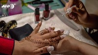 Perayaan Idul Adha di Asia Timur dan Asia Tenggara berlangsung meriah. Misalnya di Afghanistan, menghias tangan dengan henna pada malam sebelum Iduladha menjadi tradisi yang dijalankan oleh perempuan dari segala usia. (Conway/AFP)