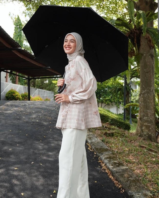 Gaya Cut Syifa ini juga bisa kamu pakai saat salat Idul Adha nanti. Palazzo pants putih dipadu blouse warna cream pastel dan hijab segi empat warna nude yang diikat rapi ke belakang. Foto: Dok. Instagram @cutsyifaa.