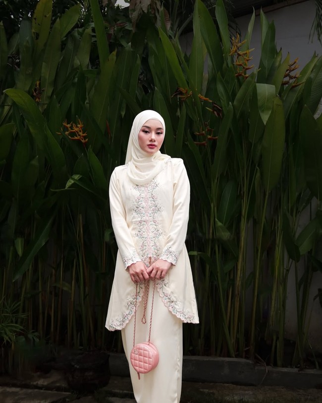 Dinda Hauw tampil memukau dengan outfit bernuansa khas Melayu yang bisa jadi inspirasi di Hari Raya Idul Adha. Atasan baju kurung dengan bordir floral, Dinda padu dengan hijab pashmina warna senada membuat penampilannya semakin elegan. Foto: Dok. Instagram @dindahw.
