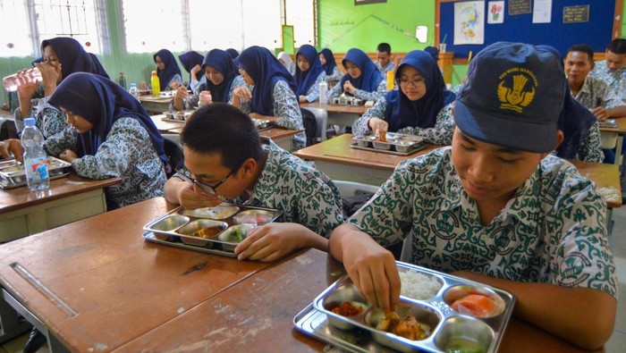 Siswa Padang Mulai Nikmati Makan Siang Gratis dari Program MBG Sejumlah siswa menikmati makan siang dari program Makan Bergizi Gratis (MBG) di SMPN 8 Padang, Sumatera Barat, Rabu (4/6/2025). Pemkot Padang memulai pelaksanaan program MBG tahap awal di 11 sekolah di Kota Padang dengan dukungan satu dapur utama serta tambahan tujuh dapur baru yang sedang dalam tahap persiapan dengan target bisa menjangkau lebih dari 100 sekolah di kota itu. ANTARA FOTO/Iggoy el Fitra