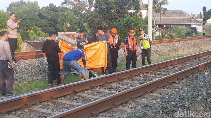 Evakuasi pria tanpa identitas yang tertabrak KRl di Pucangsawit, Solo, Kamis (5/6/2025).