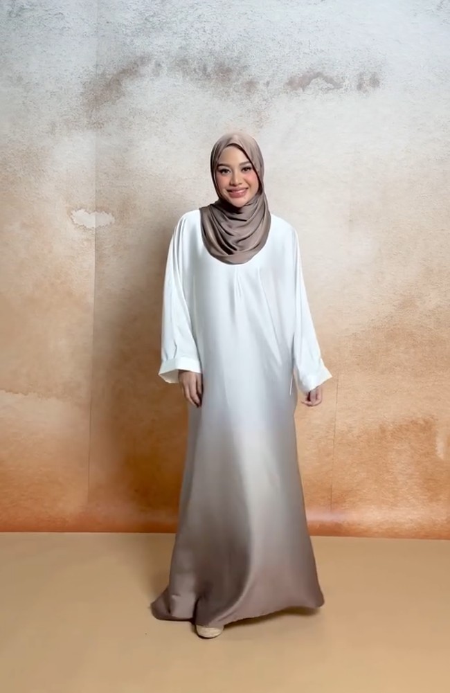 Aurel Hermansyah tampil memukau dalam balutan gamis gradasi warna putih dan cokelat yang memberi kesan lembut dan elegan. Dipadukan dengan hijab simpel, gaya ini sangat cocok untuk wanita usia 20-an yang ingin tampil anggun tanpa berlebihan. Foto: Dok. Instagram @lozyhijab.