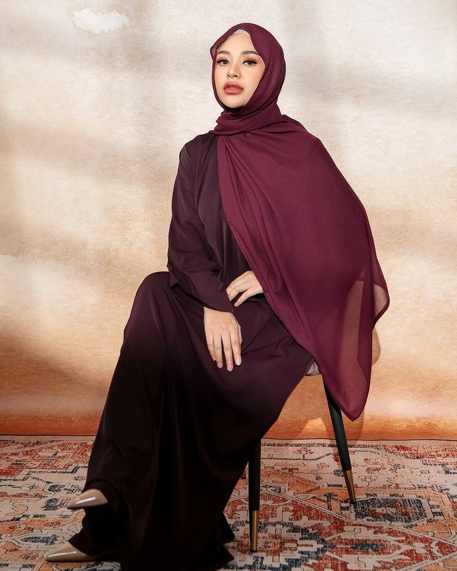 Aurel Hermansyah tampil anggun dengan gamis burgundy yang dipadukan dengan hijab pashmina polos senada. Gaya ini memberi kesan feminin dan elegan, sangat cocok untuk wanita usia 20-an yang ingin tampil modis namun tetap sopan. Foto: Dok. Instagram @aurelie.hermansyah.