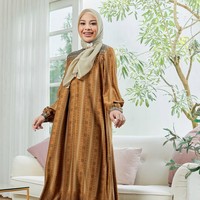 Istri YouTuber Atta Halilintar ini tampil memukau saat memakai dress motif dengan hijab segi empat warna khaki. Perpaduan warna dan motifnya yang selaras bikin penampilan kamu jadi terlihat mewah. Foto: Dok. Instagram @geelafashion.