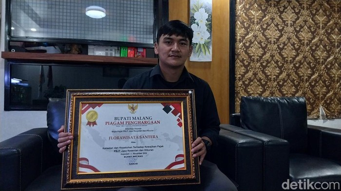 Humas Florawisata Santerra De Laponte Arif menunjukkan piagam penghargaan dari Bupati Malang