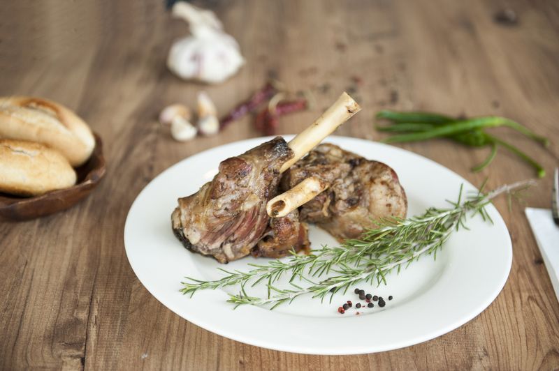 Roast Leg of Lamb on the plate on wooden table