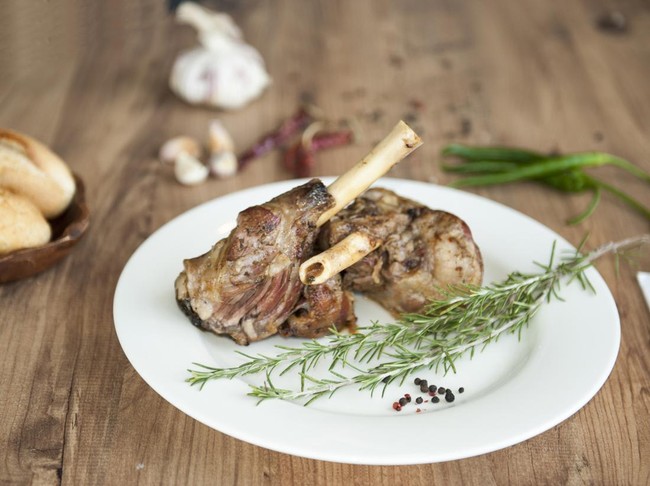 Roast Leg of Lamb on the plate on wooden table