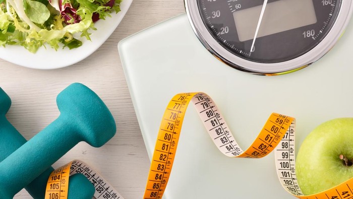 Conceptual healthy life background with dumbbell scales and healthy food. Top view. Horizontal composition.