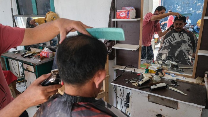 Jasa pangkas rambut jelang Idul Adha di Kendari Dua orang tukang pangkas rambut melayani pelanggan di kios cukur rambut di kawasan Korem, Kendari, Sulawesi Tenggara, Kamis (5/6/2025). H-1 menjelang hari raya Idul Adha, jumlah pelanggan yang datang untuk memangkas rambut di kawasan tersebut meningkat sebanyak 100 persen dibandingkan tahun lalu dan hari biasanya dengan tarif Rp30 ribu per orang. ANTARA FOTO/Andry Denisah/bar