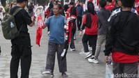 Supporter yang mulai berdatangan membeli suvenir yang dijual.