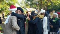 Foto: Momen jemaah An-Nadzir saling bersalaman dan berpelukan selepas salat Idul Adha 2025. Jemaah An-Nadzir tampil dengan warna pakaian didominasi hitam.