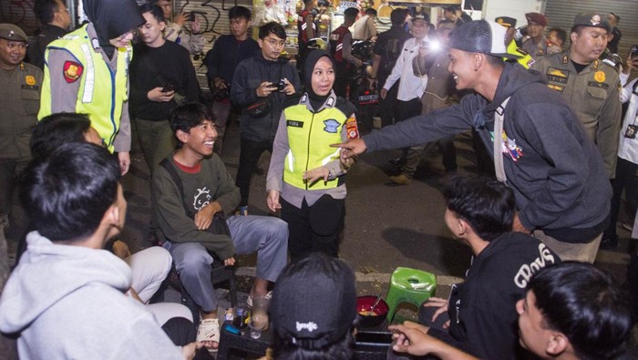 Pelajar Bandung Dilarang Keluyuran Lewat Jam 9 Malam Wakil Wali Kota Bandung Erwin (kedua kiri) didampingi Kapolrestabes Bandung Kombes Pol Budi Sartono (kiri) menyampaikan edukasi dan imbauan kepada warga saat patroli jam malam pelajar di Bandung, Jawa Barat, Rabu (4/6/2025). Pemerintah Kota Bandung mulai memberlakukan aturan jam malam dari Gubernur Jawa Barat tentang pelarangan aktivitas bagi pelajar atau peserta didik di luar rumah mulai pukul 21.00 WIB hingga 04.00 WIB. ANTARA FOTO/Novrian Arbi/nz